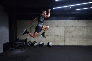 Image showing A muscular man captured in air as he jumps in a modern gym, showcasing his athleticism, power, and determination through a highintensity fitness routine