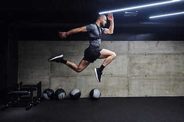 Image showing A muscular man captured in air as he jumps in a modern gym, showcasing his athleticism, power, and determination through a highintensity fitness routine