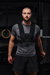 Image showing A muscular man working arm exercises in a modern gym, showcasing his strength and dedication to fitness.