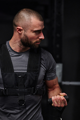 Image showing A muscular man working arm exercises in a modern gym, showcasing his strength and dedication to fitness.