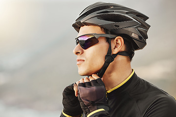 Image showing Cycling, helmet and sunglasses with a sports man being safe while outdoor for a ride on a cloudy day. Safety, cycle and fitness with a male athlete outside to exercise or workout for cardio health