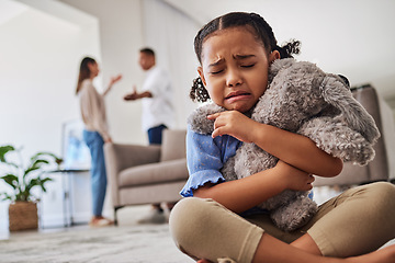 Image showing Sad, little girl and crying from parent fight, argument or divorce hugging teddy at home. Unhappy young child in depression, stress and anxiety from mother and father fighting in family disagreement