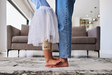 Image showing Feet, child and mother teaching a dance ballet movement on the living room floor together in their house. Legs of a girl kid learning and dancing to music with her mom in the lounge of their home