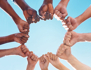 Image showing Fist hands, circle and diversity support human rights people, protest group and freedom of racism on blue sky background. Below solidarity, partnership and motivation of goals, trust or world justice
