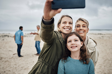 Image showing Phone, selfie and beach with a girl, mother and grandmother taking a family photograph on the sand by the sea while on vacation. Summer, technology and love with female relatives posing for a picture