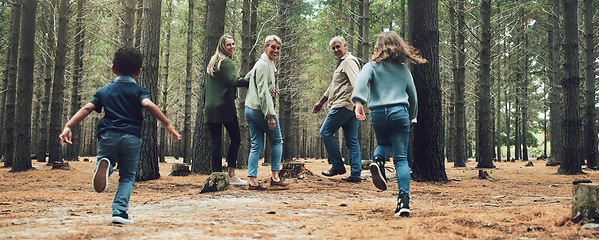 Image showing Forest, big family and adventure with children, parents and grandparents walking in nature for outdoor hiking, fun and trees on wellness vacation. Running kids, travel and happy man and women in wood
