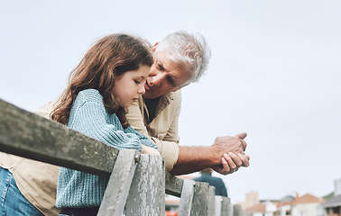 Image showing Talking, children and love with a girl and grandfather bonding or spending time together outdoor on a pier. Conversation, care and relationship with a senior man and granddaughter chatting outside