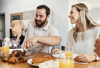 Image showing Family, food and man cutting chicken at dinner party with woman smiling, eating and drinking together in dining room. Happy, care and celebrate, share time with couple and friends in home in Canada.