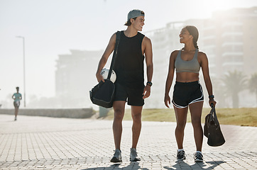 Image showing Sports, personal trainer and woman in fitness walking with a soccer ball for cardio exercise, workout and training session. Smile, wellness and happy couple enjoy a healthy city lifestyle in summer