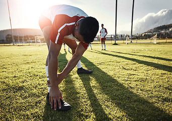 Image showing Football, athlete and man doing a stretching exercise for legs on a sport field before a match. Sports, fitness and healthy guy doing a warm up workout at soccer training on a pitch for a game.