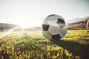 Image showing Soccer, sports and ball on field for game with sunshine on green grass for tournament match. Football, cardio and competition day with foreground and sunlight flare on athletic ground.