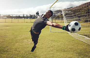 Image showing Soccer, sports and goalkeeper training on a field for a professional competition. Young and strong athlete with energy and motivation catching a football during a game or exercise on a sport ground