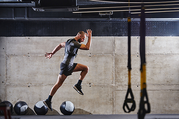 Image showing A muscular man captured in air as he jumps in a modern gym, showcasing his athleticism, power, and determination through a highintensity fitness routine