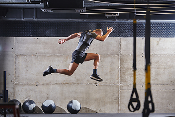 Image showing A muscular man captured in air as he jumps in a modern gym, showcasing his athleticism, power, and determination through a highintensity fitness routine