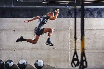 Image showing A muscular man captured in air as he jumps in a modern gym, showcasing his athleticism, power, and determination through a highintensity fitness routine