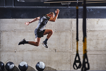 Image showing A muscular man captured in air as he jumps in a modern gym, showcasing his athleticism, power, and determination through a highintensity fitness routine