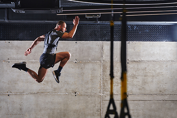 Image showing A muscular man captured in air as he jumps in a modern gym, showcasing his athleticism, power, and determination through a highintensity fitness routine