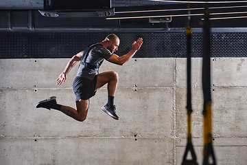 Image showing A muscular man captured in air as he jumps in a modern gym, showcasing his athleticism, power, and determination through a highintensity fitness routine