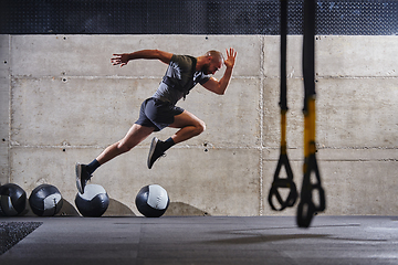 Image showing A muscular man captured in air as he jumps in a modern gym, showcasing his athleticism, power, and determination through a highintensity fitness routine