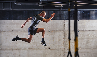 Image showing A muscular man captured in air as he jumps in a modern gym, showcasing his athleticism, power, and determination through a highintensity fitness routine