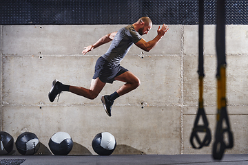 Image showing A muscular man captured in air as he jumps in a modern gym, showcasing his athleticism, power, and determination through a highintensity fitness routine