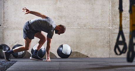 Image showing A muscular man captured in air as he jumps in a modern gym, showcasing his athleticism, power, and determination through a highintensity fitness routine