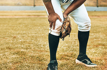 Image showing Man, baseball and sport leg injury suffering in pain, agony and discomfort during training match or game on the field. Male athlete hurt holding painful area in sports accident on grass or pitch