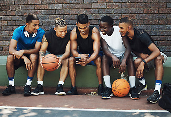 Image showing Basketball friends, rest together with phone and relax watch a funny video on smartphone after training on sports court. Healthy men, relax and tired on bench after workout game for fitness exercise