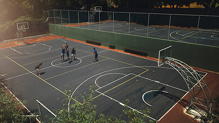 Image showing Basketball, outdoor court and athlete men showing energy in ball sports competition or game for fitness and training. Above view, exercise and sport with community people playing streetball together