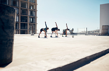 Image showing Soccer, sports and fitness with a team stretching on a rooftop court before a game or match outdoor. Football, training and health with a man and woman athlete group getting ready to play a sport