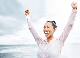 Image showing Happy woman, beach fitness success and achievement, freedom and motivation goals, energy and wellness on clouds sky background. Excited sports female winner, fist arms up celebration and inspiration