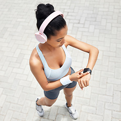 Image showing Fitness, woman and watch of runner time monitoring health, performance and distance above outdoors. Active female checking wrist app after a run outside listening to music for training and exercise
