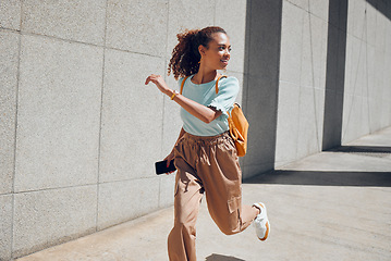 Image showing Woman, travel and city with backpack, running and street for holiday, vacation or traveling. Black woman, tourist and outdoor in urban, metro or town in summer, sunshine and smile in Cape Town