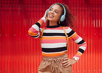 Image showing Music headphone streaming, happy and fashion black woman smile outdoor in Brazil. Happiness of a girl feeling relax freedom and cheerful mindset listening to audio and song track with red background