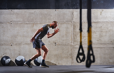 Image showing A muscular man captured in air as he jumps in a modern gym, showcasing his athleticism, power, and determination through a highintensity fitness routine