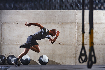 Image showing A muscular man captured in air as he jumps in a modern gym, showcasing his athleticism, power, and determination through a highintensity fitness routine