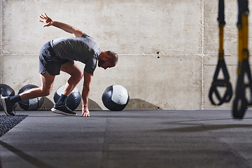 Image showing A muscular man captured in air as he jumps in a modern gym, showcasing his athleticism, power, and determination through a highintensity fitness routine