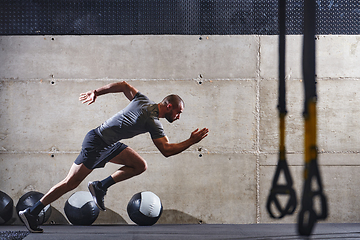 Image showing A muscular man captured in air as he jumps in a modern gym, showcasing his athleticism, power, and determination through a highintensity fitness routine