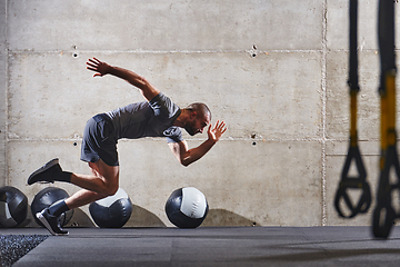 Image showing A muscular man captured in air as he jumps in a modern gym, showcasing his athleticism, power, and determination through a highintensity fitness routine