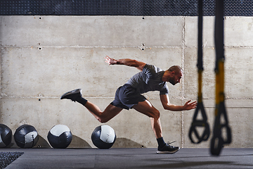 Image showing A muscular man captured in air as he jumps in a modern gym, showcasing his athleticism, power, and determination through a highintensity fitness routine