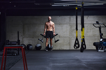 Image showing A muscular man performs shoulder exercises in a modern gym, showcasing his strength and dedication to fitness.