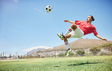 Image showing Fitness, soccer and athlete scoring a goal at a game or sports training at an outdoor field. Skill, jump and man football player practicing a kick and score with ball exercise on pitch for motivation