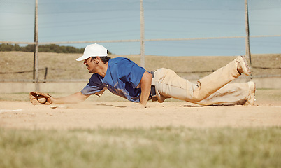 Image showing Sports, action and a man catching baseball, sliding in dust on floor with ball in baseball glove. Slide, dive and catch, baseball player on the ground during game, professional athlete on the field.