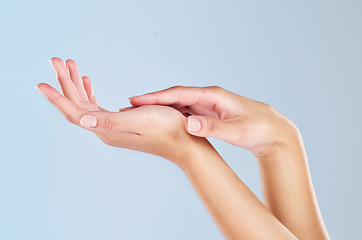 Image showing Skincare, beauty and manicure with hands of woman and massage palm for wellness, health and spa against a blue background in studio. Salon, cosmetics and luxury with girl hand for clean dermatology