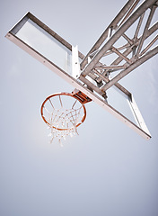 Image showing Basketball, sports and net with a hoop on a court on a cloudy day from below for training or exercise. Fitness, workout and health with sport equipment outdoor for practice or a competitive game