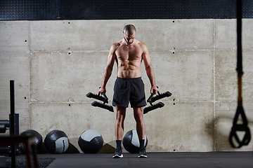 Image showing A muscular man performs shoulder exercises in a modern gym, showcasing his strength and dedication to fitness.