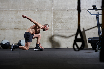 Image showing A muscular man standing in the starting position for running, exuding determination and readiness for an intense fitness workout or athletic competition.