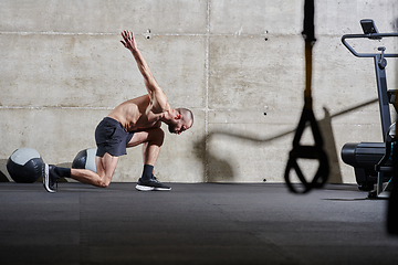 Image showing A muscular man standing in the starting position for running, exuding determination and readiness for an intense fitness workout or athletic competition.