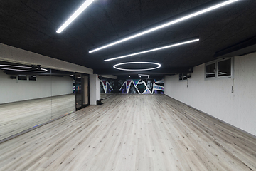 Image showing An empty dance hall with a glass wall adorned with decorative graffiti, offering a fusion of contemporary, urban artistic ambiance and impressive aesthetics.