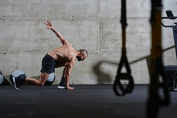 Image showing A muscular man standing in the starting position for running, exuding determination and readiness for an intense fitness workout or athletic competition.